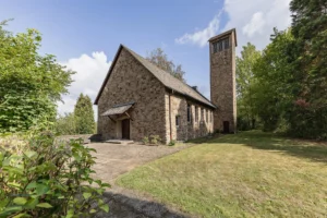 Besonderes Ensemble auf Erbpachtgrundstück: Kirche, Pfarrhaus und Freifläche in grüner Umgebung